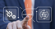 A person in a suit touches holographic symbols with the word "Customize" as they interact with a digital interface.